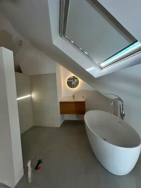 Badkamer met vrijstaand bad en lichtinval via dakraam